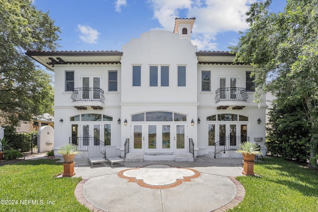 24554 Harbour View Dr, Ponte Vedra Beach, FL 32082 - rear view of house with french doors, a balcony, a tile roof, and a lawn