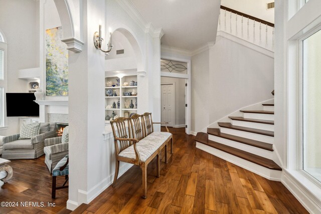 foyer entrance with ornamental molding, a towering ceiling, and dark hardwood / wood-style flooring