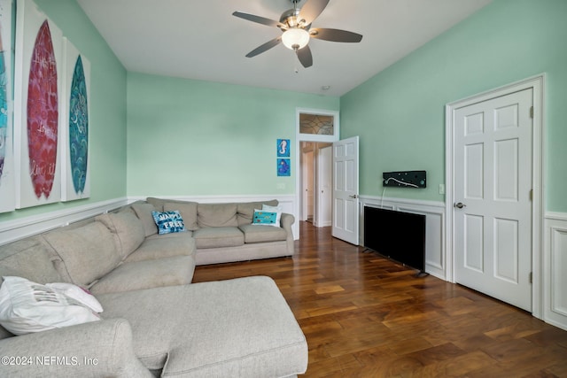 living room with ceiling fan and dark hardwood / wood-style flooring