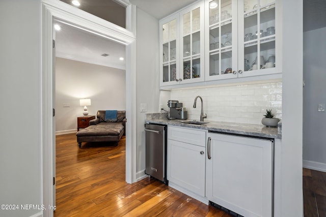 bar featuring tasteful backsplash, sink, white cabinets, light stone counters, and dark wood-type flooring