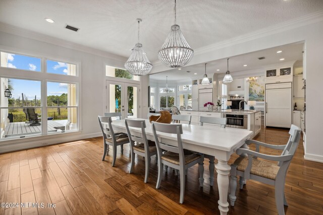 dining room with dark hardwood / wood-style flooring, sink, french doors, and a chandelier