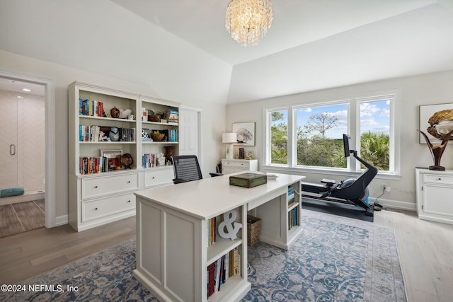 office area featuring vaulted ceiling, an inviting chandelier, and light wood-type flooring