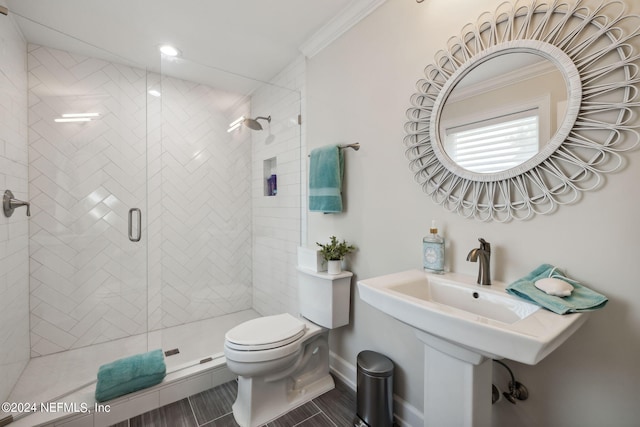 bathroom with crown molding, toilet, and a shower with shower door