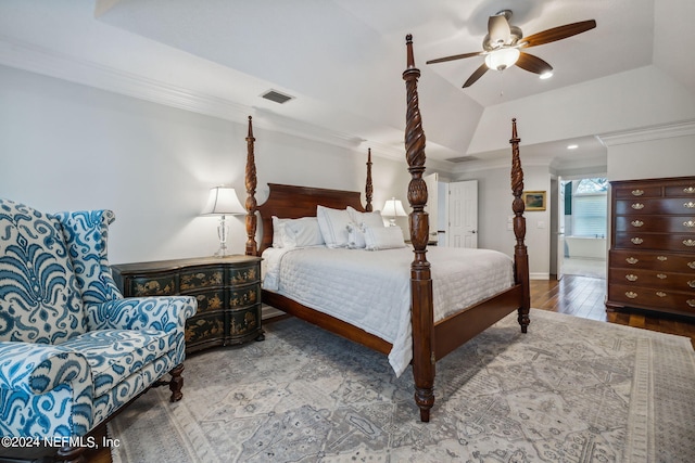 bedroom featuring lofted ceiling, wood-type flooring, ornamental molding, a raised ceiling, and ceiling fan