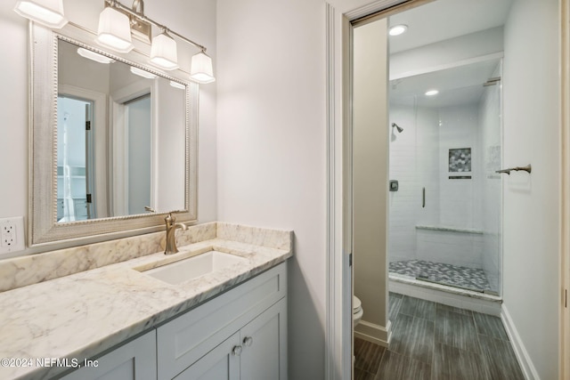 bathroom featuring vanity, toilet, and a shower with door