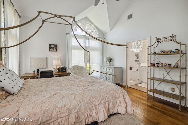 bedroom featuring ensuite bath, wood-type flooring, and high vaulted ceiling