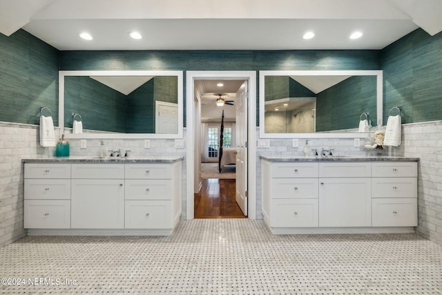 bathroom with ceiling fan, vanity, and tile walls