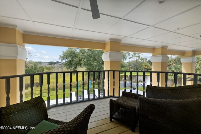 balcony with ceiling fan and a water view