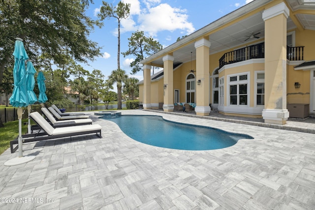 view of pool featuring a patio, ceiling fan, and an in ground hot tub