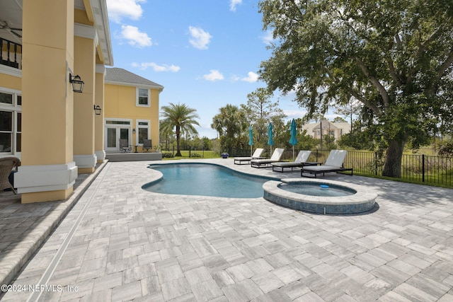 view of swimming pool featuring a patio area, french doors, and an in ground hot tub