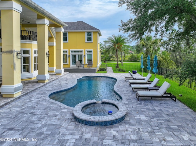 view of pool featuring a patio, ceiling fan, an in ground hot tub, and a lawn