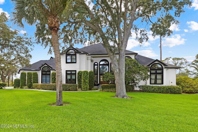 french country home featuring a front lawn