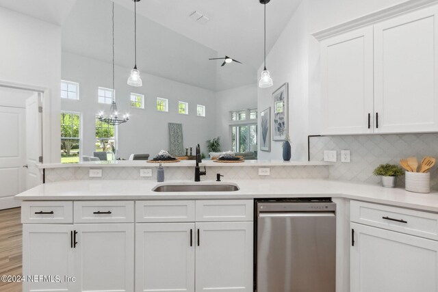 kitchen featuring vaulted ceiling, dishwasher, light hardwood / wood-style floors, decorative light fixtures, and sink