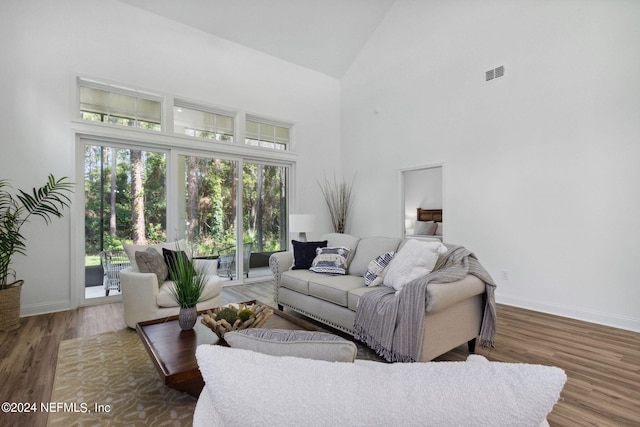 living room featuring high vaulted ceiling and hardwood / wood-style flooring