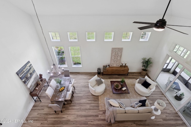 living room featuring high vaulted ceiling, ceiling fan, and wood-type flooring