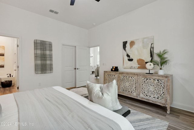 bedroom with ensuite bathroom, ceiling fan, and hardwood / wood-style floors