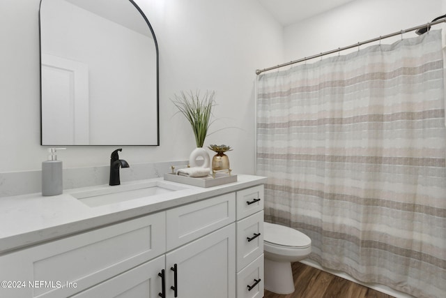 bathroom with vanity, toilet, and hardwood / wood-style floors