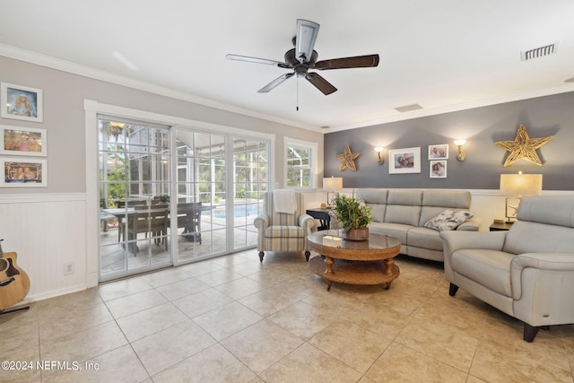 living room featuring ceiling fan, light tile patterned floors, and crown molding