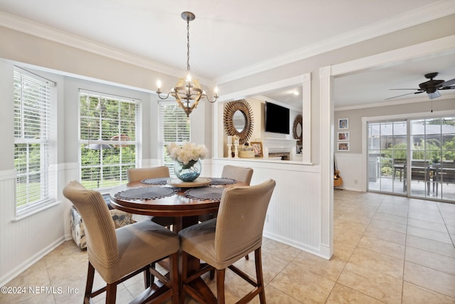 dining room with ceiling fan with notable chandelier, ornamental molding, and light tile patterned flooring