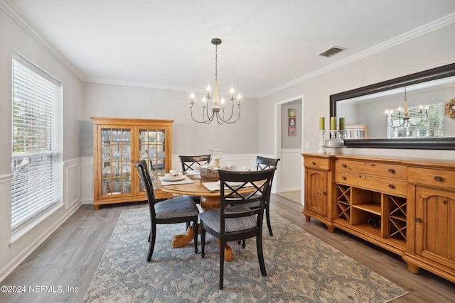 dining area with crown molding, hardwood / wood-style floors, and a chandelier