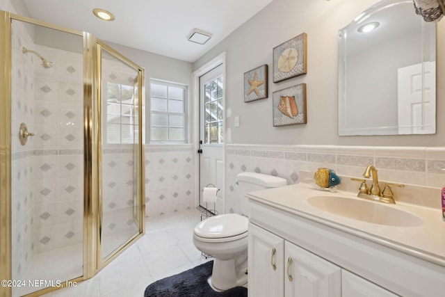 bathroom with vanity, tile patterned floors, toilet, walk in shower, and tile walls