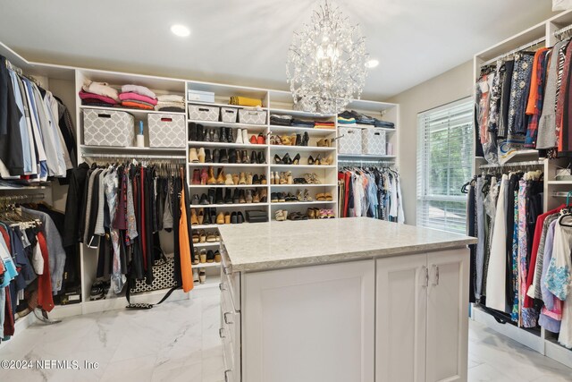 walk in closet with an inviting chandelier