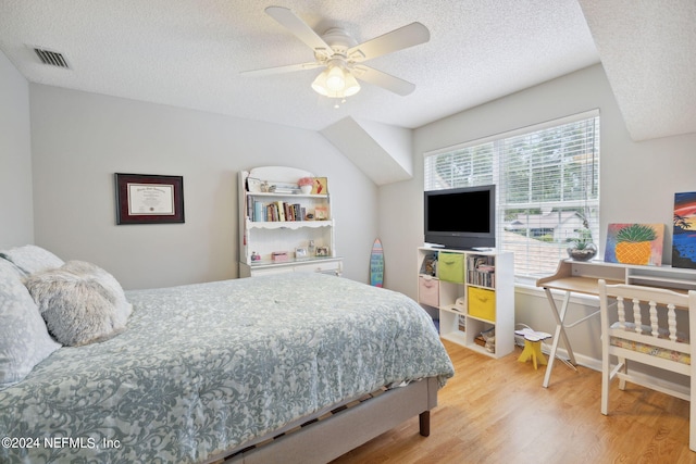 bedroom with multiple windows, ceiling fan, wood-type flooring, and a textured ceiling