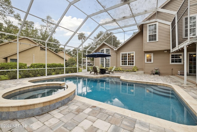 view of swimming pool featuring a lanai, a patio area, and an in ground hot tub