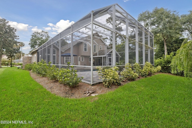 exterior space with a lanai and a lawn