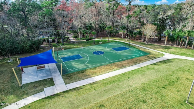 view of sport court with a lawn