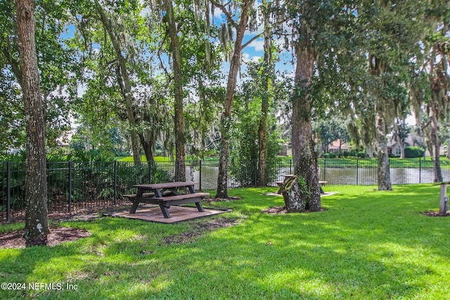 view of community with a yard and a water view