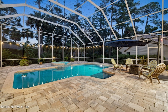 view of swimming pool featuring glass enclosure, a patio area, and an in ground hot tub