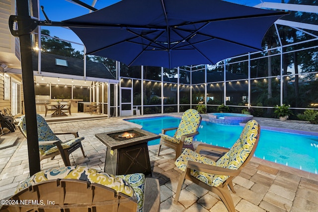 view of pool with a patio area, an in ground hot tub, glass enclosure, and a fire pit