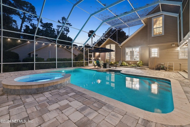 pool at dusk with glass enclosure, an in ground hot tub, and a patio