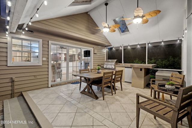 dining area with high vaulted ceiling, ceiling fan, light tile patterned floors, and wooden walls