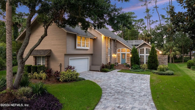 view of front of property with a yard and a garage