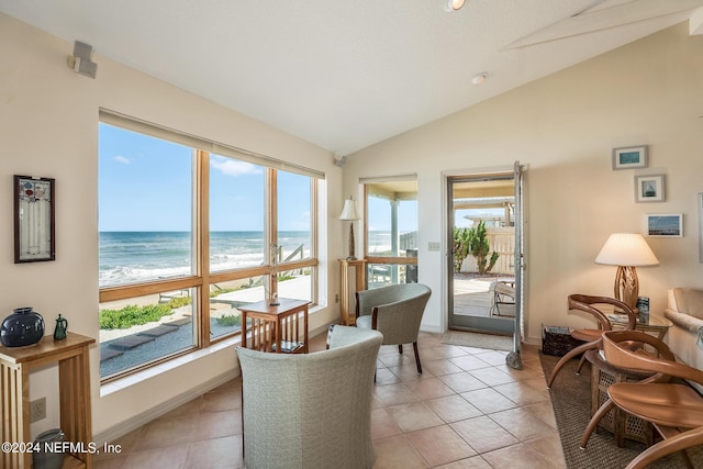 sunroom featuring a view of the beach, vaulted ceiling, and a water view