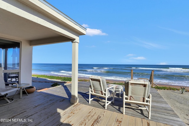 deck with a water view and a beach view