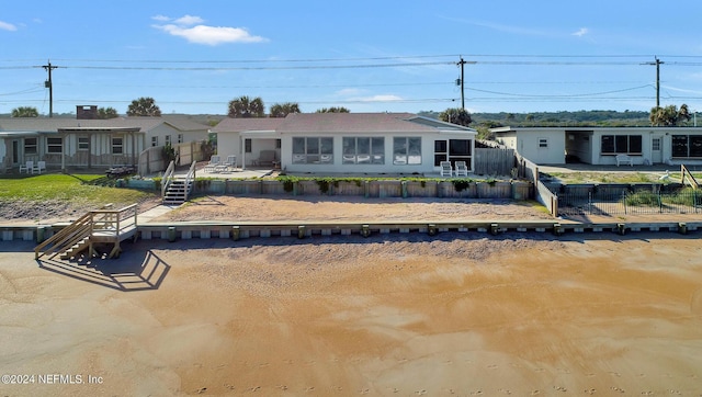 back of house featuring a sunroom and a fenced backyard