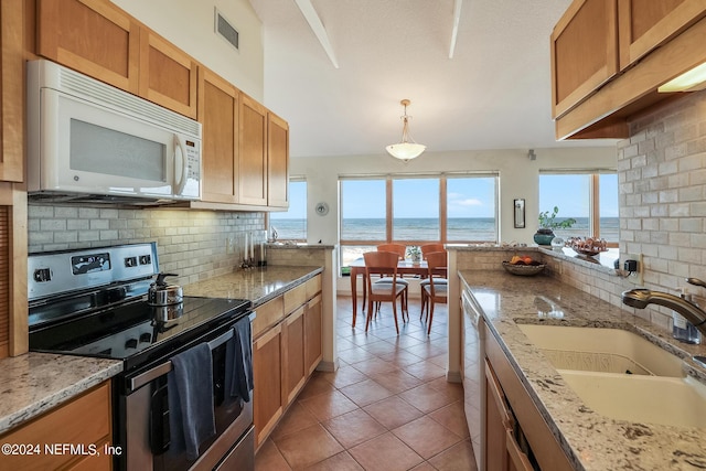 kitchen with visible vents, backsplash, a sink, white appliances, and plenty of natural light