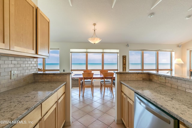 kitchen with light tile patterned floors, a water view, stainless steel dishwasher, decorative backsplash, and light stone countertops