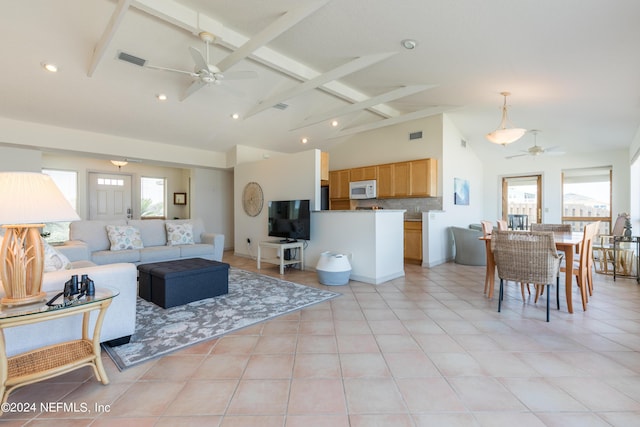 living room with vaulted ceiling with beams, light tile patterned floors, visible vents, and a ceiling fan