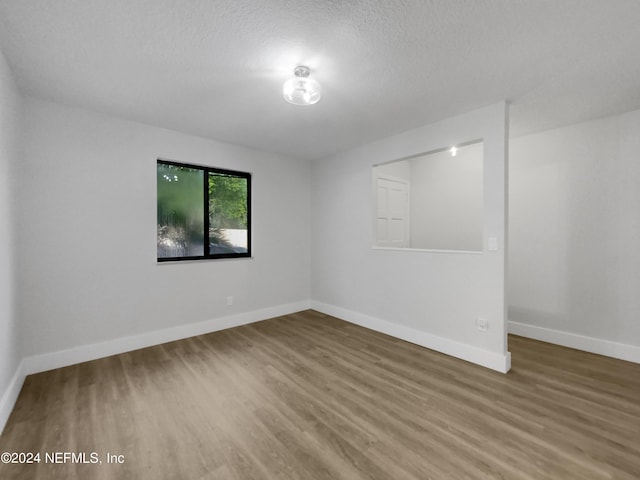 spare room featuring a textured ceiling and wood-type flooring