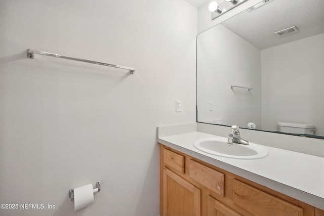 half bathroom featuring vanity and toilet