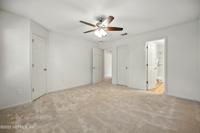 unfurnished bedroom featuring carpet floors, baseboards, and ensuite bath