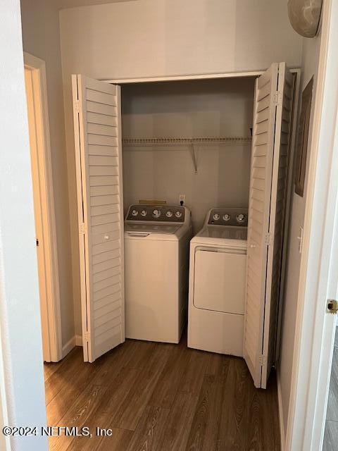 washroom with dark wood-type flooring and washing machine and clothes dryer