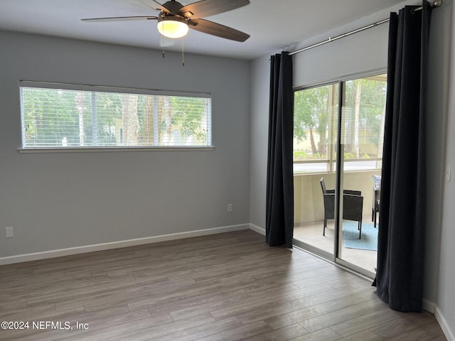 empty room featuring ceiling fan, a healthy amount of sunlight, and light wood-type flooring