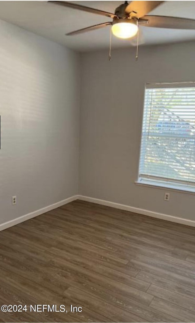 unfurnished room featuring ceiling fan and dark hardwood / wood-style floors