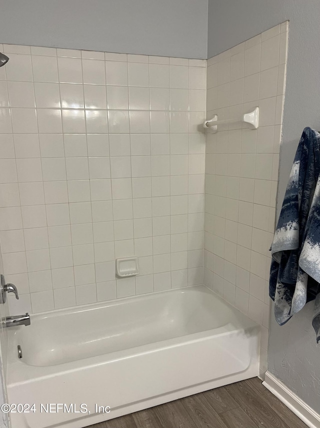 bathroom featuring hardwood / wood-style flooring and tiled shower / bath