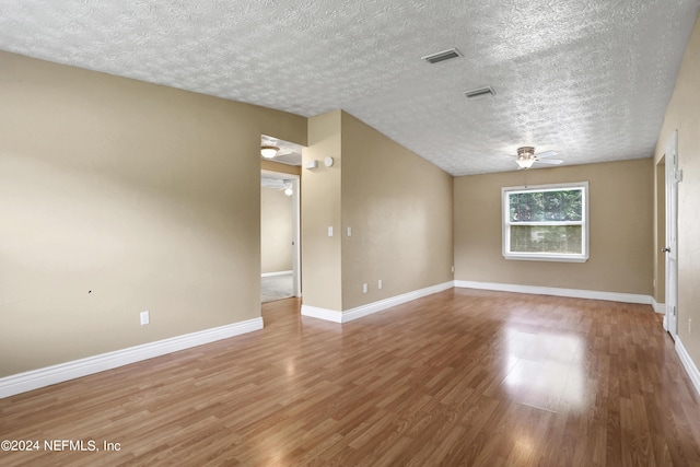 spare room featuring hardwood / wood-style flooring, a textured ceiling, and ceiling fan